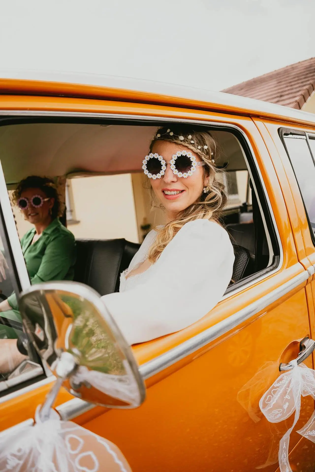la-mariee-dans-le-combi-van-jaune.jpg La mariée qui porte des lunettes marguerite dans un combi van jaune.