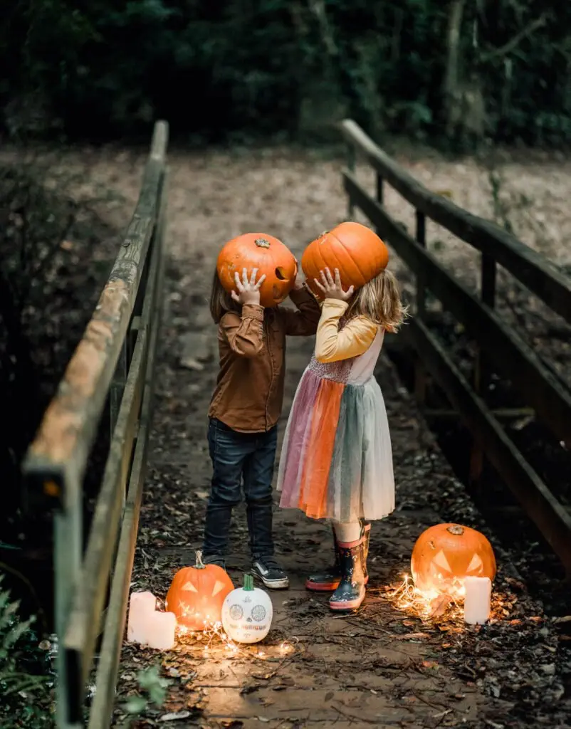 deux enfants avec des têtes de citrouilles pour un shooting d